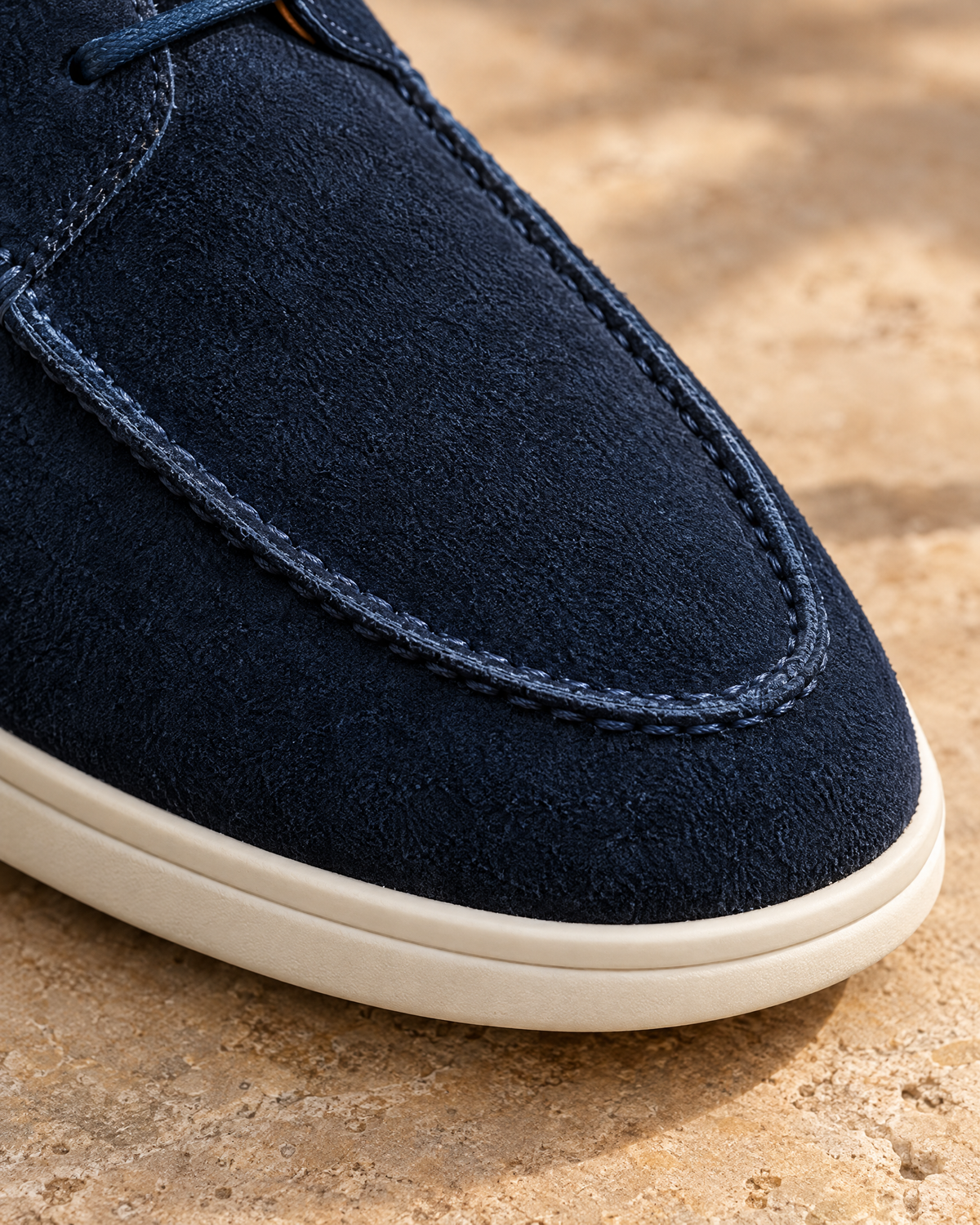 The Milano in navy suede, hand-stitched apron seam close-up - VIA NOVA